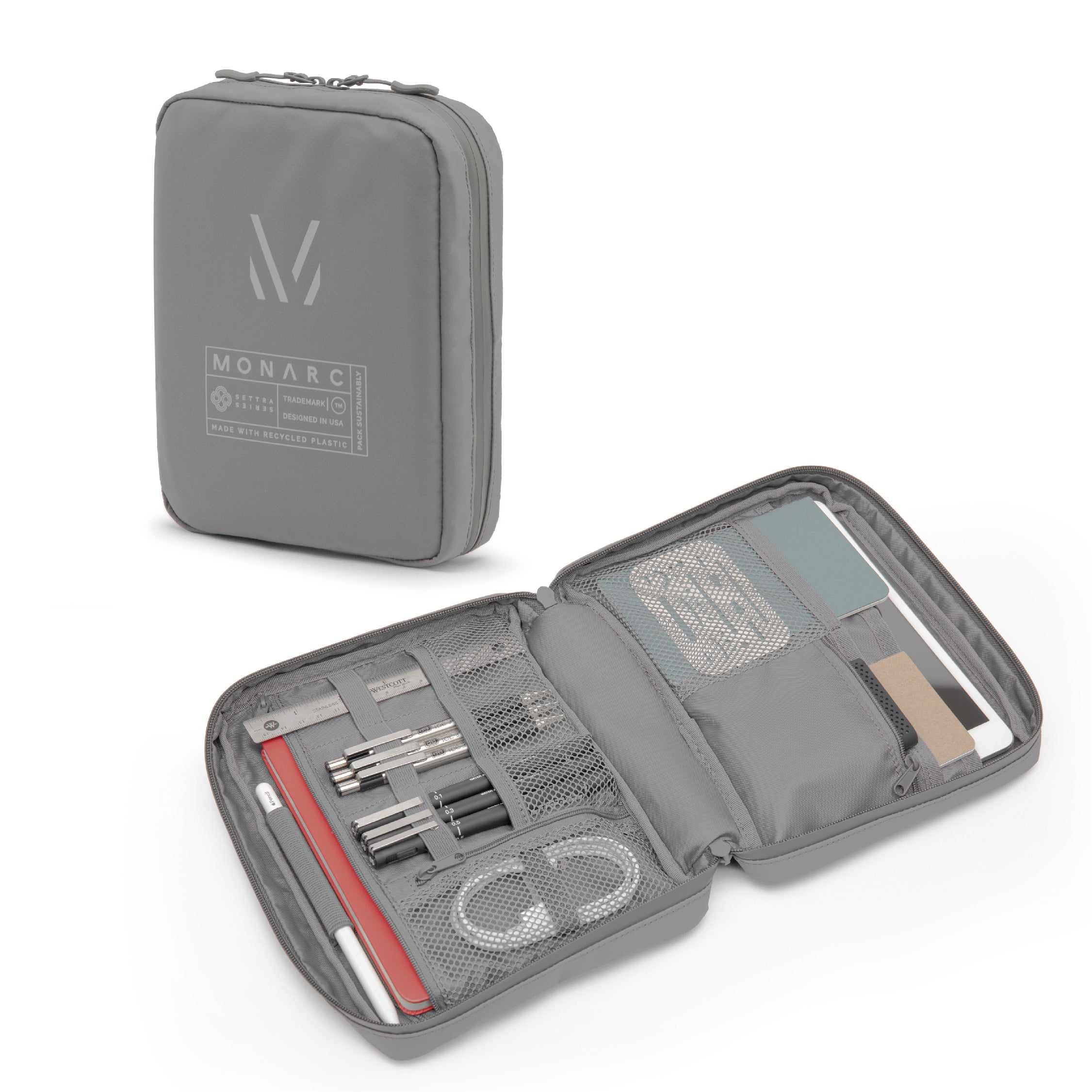 Monarc Tech Pack in gray displayed open, showcasing its ample storage options with multiple compartments for stationery and tech gear. The design features dedicated slots for pens, journals, and essential accessories, structured within a compact and sleek profile. The Tech Pack is crafted from eco-friendly, recycled materials, highlighting Monarc's commitment to sustainable design and functionality. Perfect for professionals who need a versatile organizer for mobile and stationary settings.