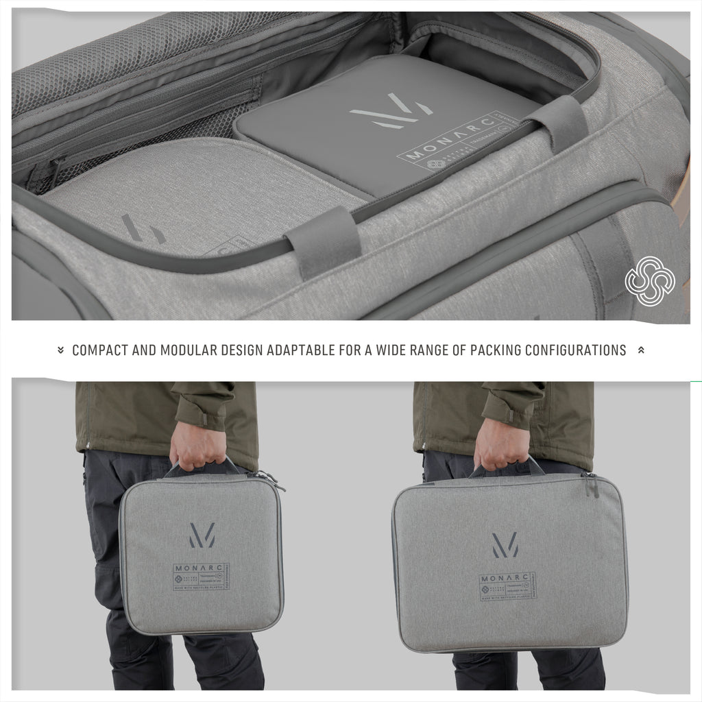 A traveler effortlessly integrates the Monarc travel set into their luggage, showcasing two sleek gray packing cubes of varying sizes. The cubes are designed with a compact and modular structure, making them perfect for a range of packing needs, from clothes to gadgets, ensuring everything stays organized and accessible in any travel scenario.